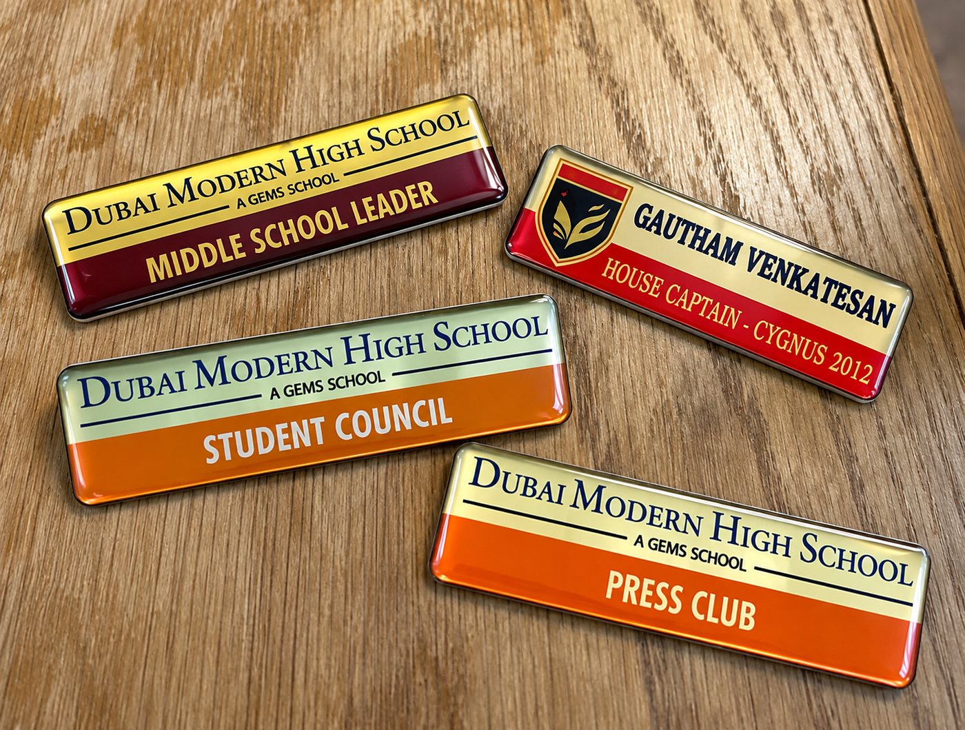 School leadership badges on a desk — Student Council, Press Club, Middle School Leader and a House Captain pin.