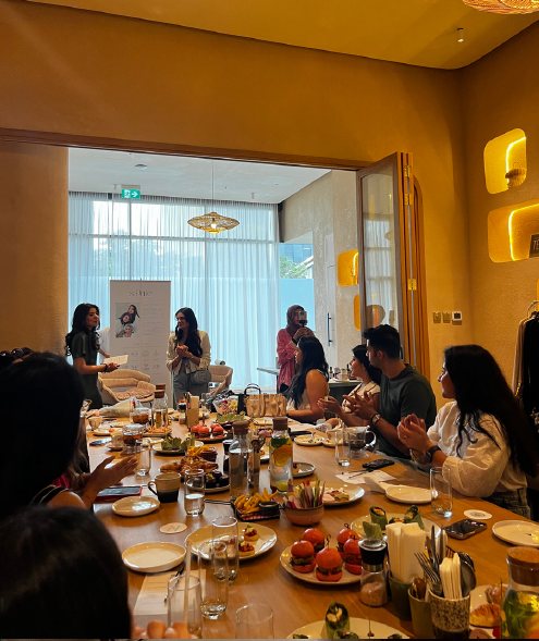 A long table of participants listening as a session opens.